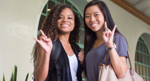 Two women doing the horns sign