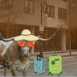 Bevo is standing in the street in front of an apartment building in West Campus. Bevo is standing next to two illustrated suitcases and is wearing a sunhat and sunglasses. 