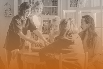 Five roommates around a table with a burnt orange gradient.