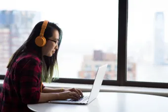 Girl with headphones using a laptop