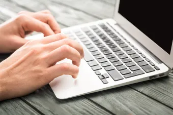 Person sitting at a table with a laptop