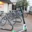 Electronic scooter parked in front of a bike rack