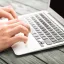 Person sitting at a table with a laptop