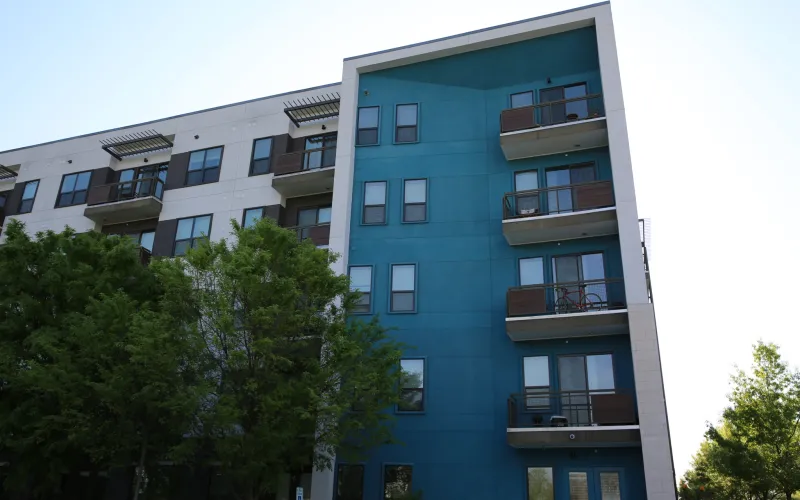 Blue and white apartment building in Austin, Texas surrounded by trees