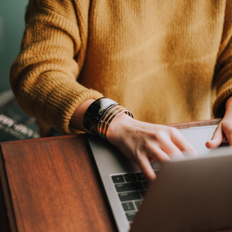 Person sitting at a table with a laptop